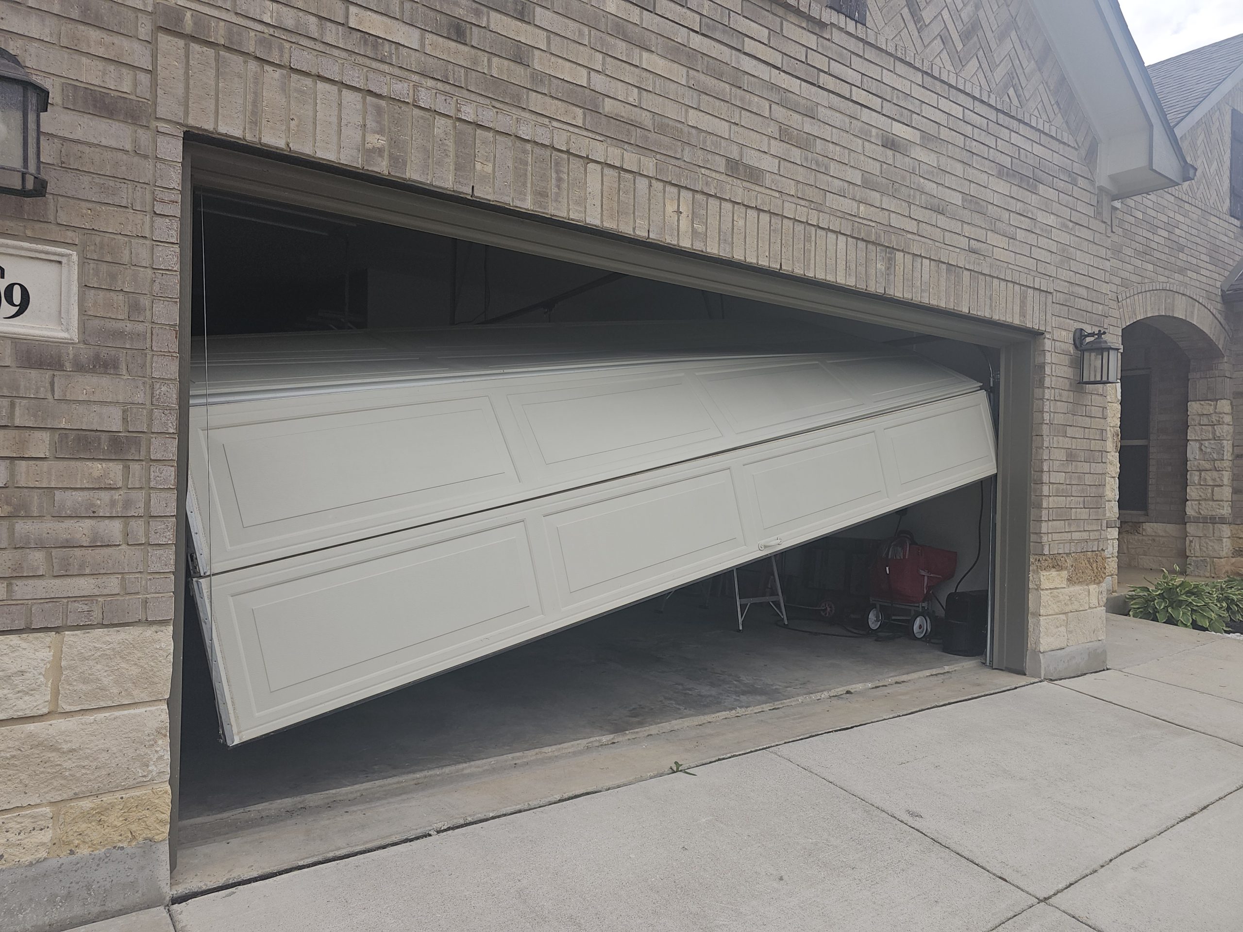 Why has my garage door fallen off its tracks and is collapsing?